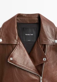 Giacca da motociclista in pelle marrone con finitura testurizzata, collo a revers, ferramenta argentata e chiusura con zip. Interno foderato con etichetta del marchio.