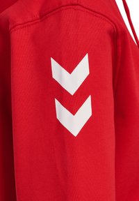 Roter Stoff mit glatter Textur, der auf dem Ärmel zwei weiße Chevron-Muster in vertikaler Ausrichtung zeigt.