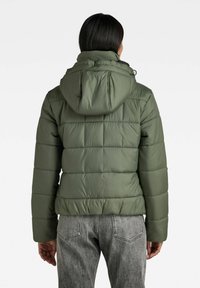 Kurtka puchowa w oliwkowej zieleni z kapturem, z pikowaną fakturą, elastycznymi mankietami i dopasowanym krojem. Widok z tyłu podkreśla design.