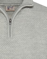 Szary sweter zapinany na zamek, wykonany z teksturowanej dzianiny. Ma wysoki kołnierz, metalowy zamek oraz metkę z logo "Schott" na szyi.