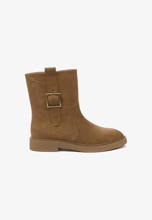 Braune Knöchelstiefel aus strukturiertem Kunstleder mit einem quadratischen Metallschnallenakzent und einer flachen Gummisohle. Runde Zehenform und minimale Nähte.