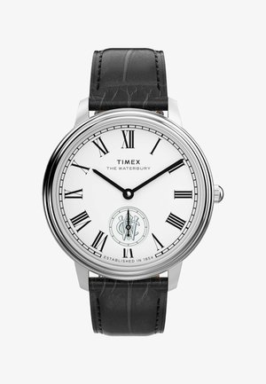 Timex Waterbury watch with a white dial, black Roman numerals, silver metal case, and textured black leather strap. Features a sub-dial.