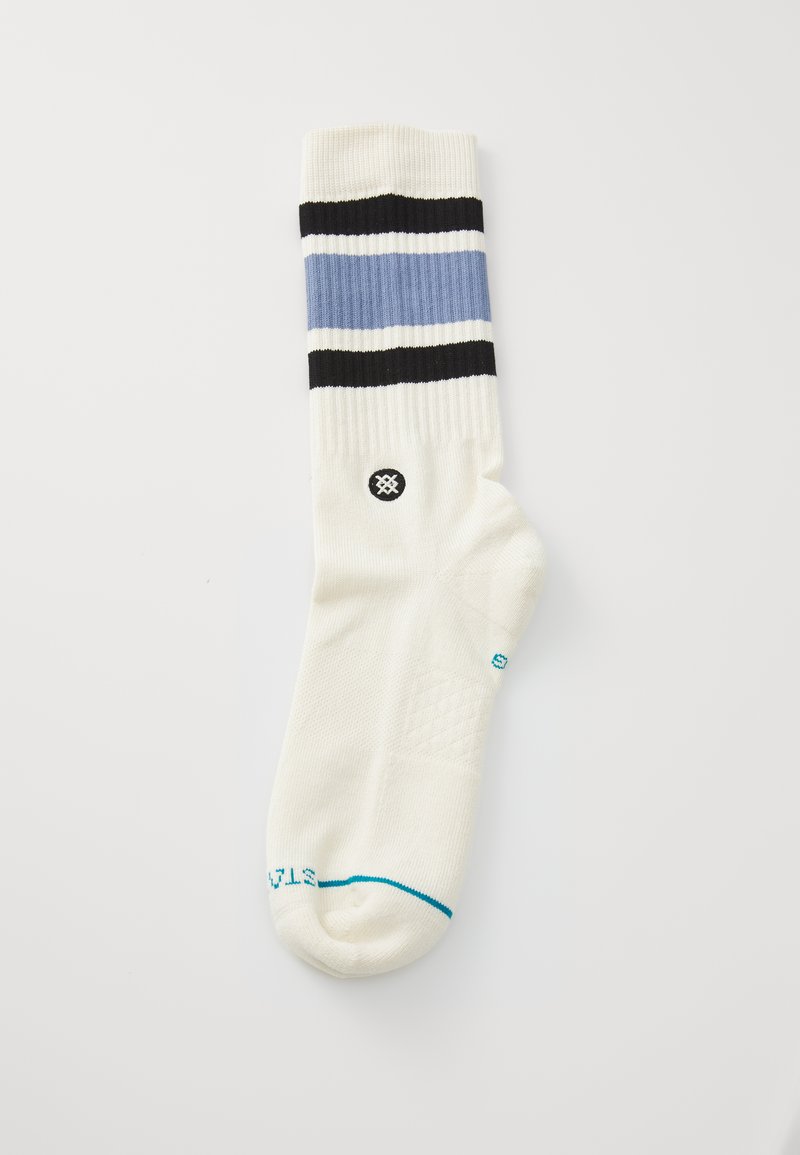 White sock with blue, black, and light blue horizontal stripes; textured fabric; blue accent near toe; black logo on ankle.