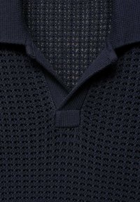 Maglione polo in maglia di colore blu navy con un motivo testurizzato, dotato di colletto classico e scollatura a V. Il tessuto è traspirante e leggero.