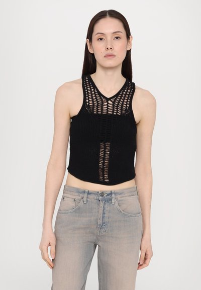 Black knitted crop top featuring a V-neck, open weave pattern on the front, and solid back. Worn with light blue wide-leg jeans.