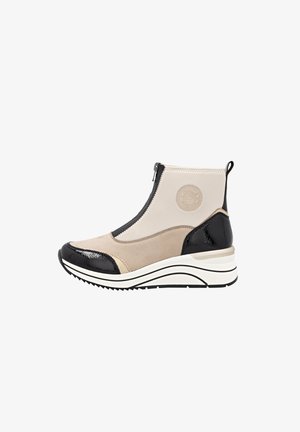 Botines estilo sneaker con parte superior de textil beige, acentos de charol negros, cremallera lateral y suela blanca gruesa con agarre texturizado.