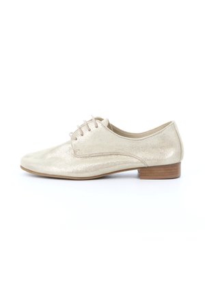 Chaussure Oxford en cuir beige avec petit talon en bois et lacets, vue de profil sur fond blanc.