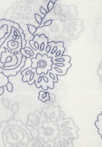 Witte stof met blauwe geborduurde bloemenpatronen met complexe details. Bevat rozenachtige en bladvormen met diverse texturen.