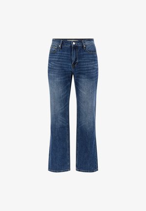 Keskmise sinise pesu denim teksad, millel on sirge jalgade lõige, viie-tasku disain, lukuga esikinnis ja nööbiga sulgemine ning peened kulumisdetailid.