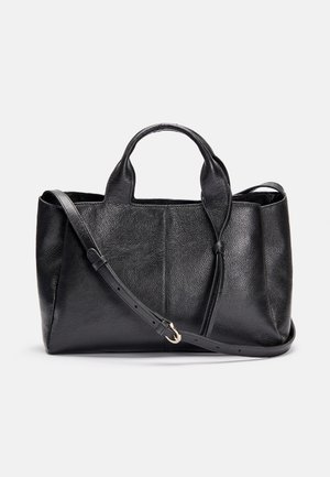 Sac en cuir noir texturé avec poignées supérieures et une bandoulière réglable reposant sur un fond blanc uni.