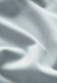 Helles blaues Baumwollgewebe mit glatter Textur, das sanfte Falten und ein dezentes geripptes Muster zeigt. Geeignet für verschiedene textile Anwendungen.