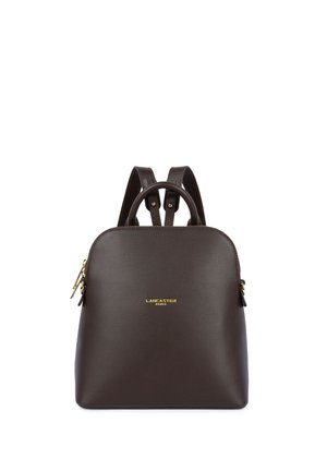 Sac à dos en cuir marron foncé Lancaster Paris avec fermeture éclair dorée, bretelles réglables et poignée supérieure sur fond blanc.