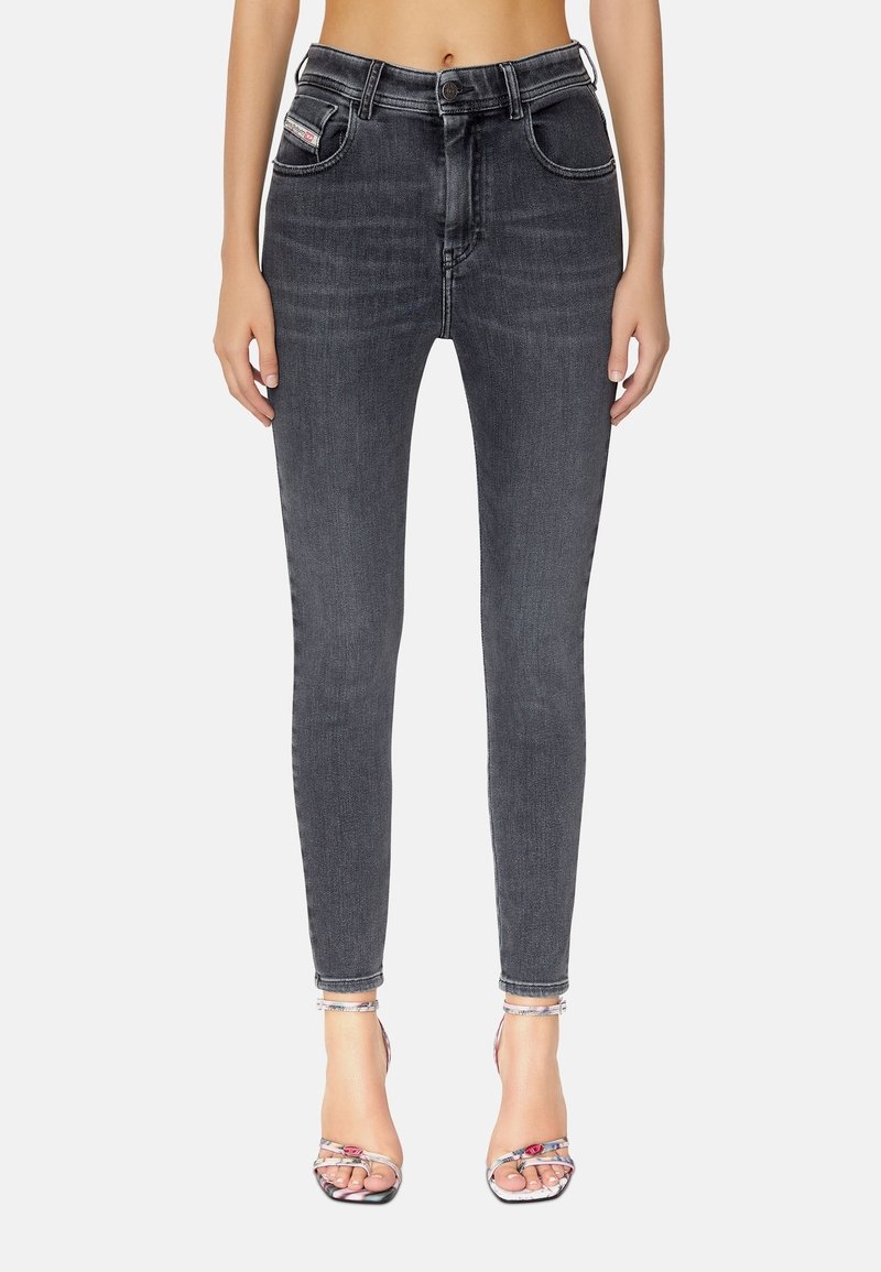 Jeans ajustados en denim gris oscuro con una textura suave, cintura alta, bolsillos frontales y detalles de costura blanca en contraste.