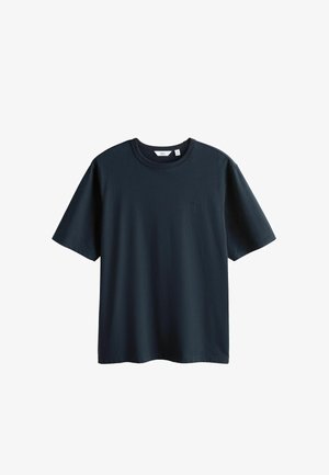 T-shirt à manches courtes de couleur bleu marine foncé uni avec un petit logo discret sur la poitrine gauche, présenté sur un fond blanc.
