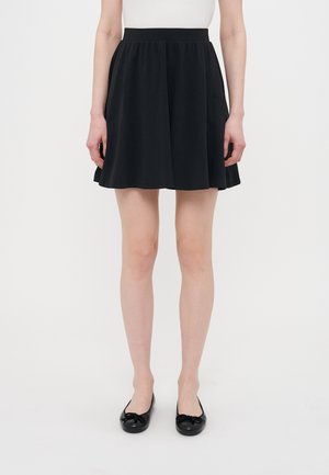 Black skater skirt made of lightweight fabric, featuring a smooth texture, elastic waistband, and flared silhouette, reaching mid-thigh.