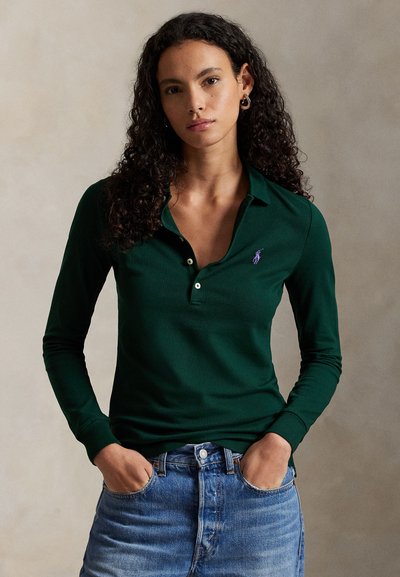 Polo vert foncé à manches longues avec une coupe décontractée, doté d'une patte de boutonnage à deux boutons et d'un logo brodé violet sur la poitrine.