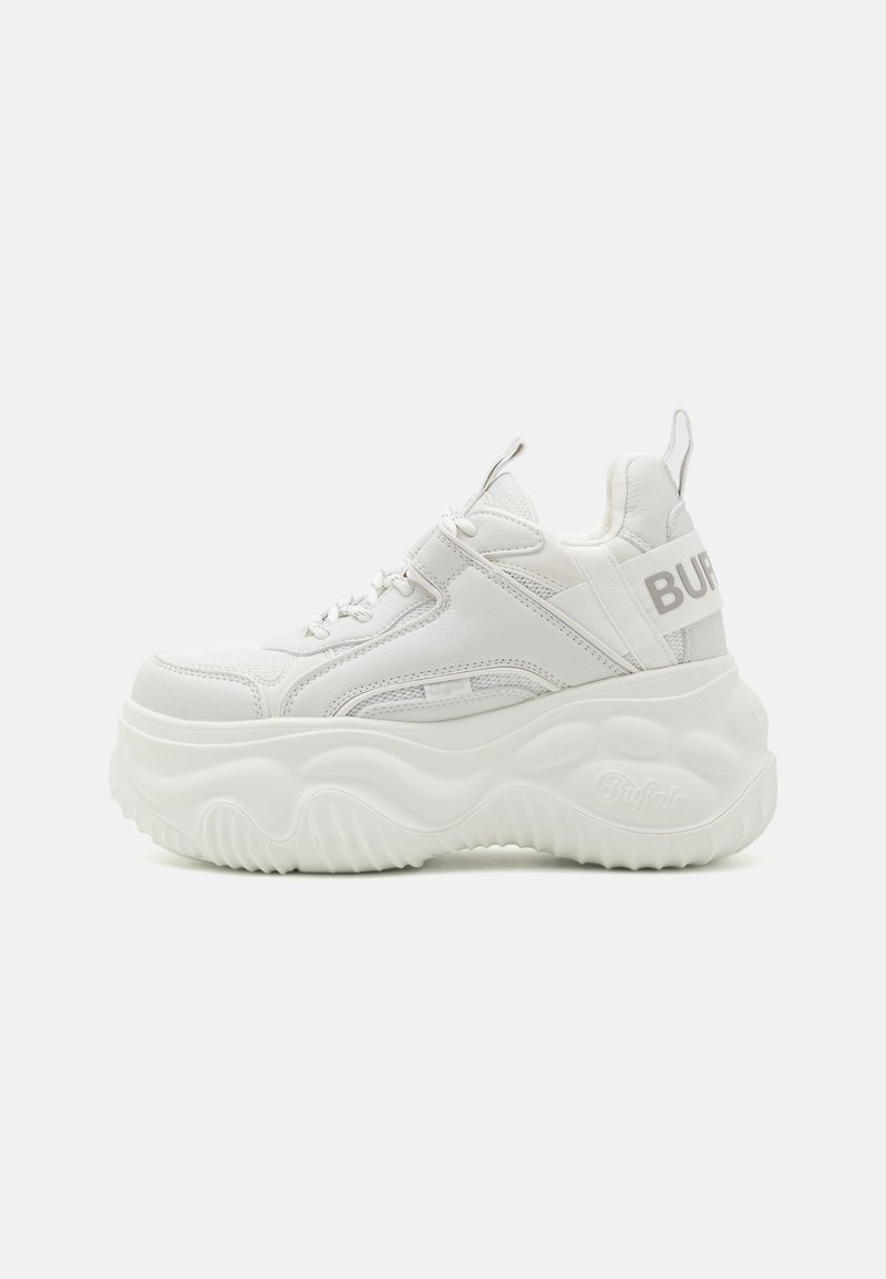 White platform sneakers made of smooth leather, featuring a textured sole and a prominent logo on the heel. Laces are centrally placed.