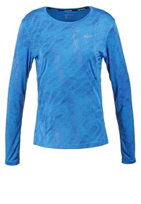 Sininen pitkähihainen urheilupaita, joka on valmistettu DRI-FIT-materiaalista, sisältää aaltoilevan kuvion ja pienen Nike-logon rinnassa.