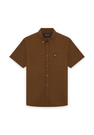 Chemise marron à manches courtes avec col, poche avant ornée d'un petit logo d'oiseau jaune, et étiquette de marque visible à l'intérieur du col.