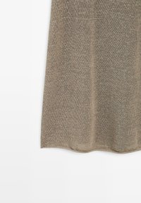 Rideau en tissu tricoté marron suspendu sur un fond blanc avec une texture subtile et une légère ondulation au bas.