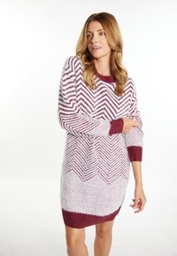 Rochie tricotată cu un model în zigzag în alb și burgundy. Guler și mansete cu textură în relief, material texturat, lungime până la genunchi.