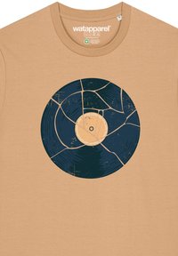 Beige T-shirt met een afbeelding van een gebarsten vinylplaat in donkerblauw en lichtbeige, met een gestructureerde uitstraling en een cirkelvormig ontwerp.