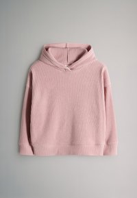 Vaaleanpunainen ribbineulottu hupullinen pitkähihaisen neulepusero, aseteltuna litteästi vaaleanharmaalle taustalle.