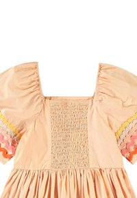 Persikofärgad klänning med puffärmar, med en smockad bodice och volangkant. Dekorativa vågmönstrade detaljer i gult, rosa och orange.