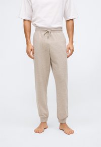 Beige sweatpants met een zachte textuur, elastische tailleband met een trekkoord, geribbelde boorden en een ontspannen pasvorm. Geschikt voor casual draag.