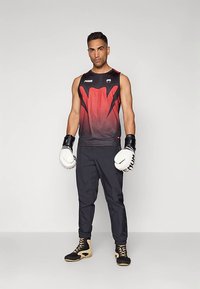 Crna i crvena bezrukavna atletska majica s gradijent uzorkom, crne hlače i bijele bokserske rukavice. Dizajnirano za izvedbu i udobnost.