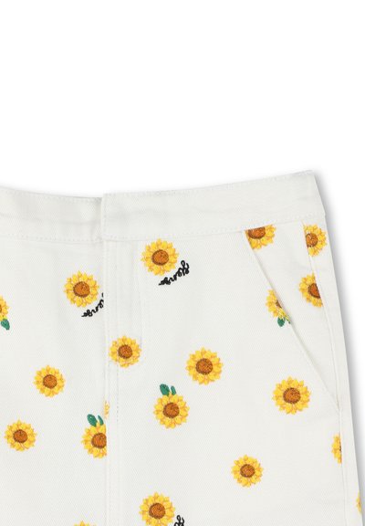 Pantalons en denim blanc avec des tournesols brodés jaunes et des feuilles vertes ; coupe droite et poches visibles ; petit détail de texte "surf".