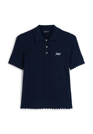 Polo de punto azul marino de manga corta con cuello, tres botones delanteros, bordes ondulados y logo blanco "tommy jeans" en el pecho izquierdo.