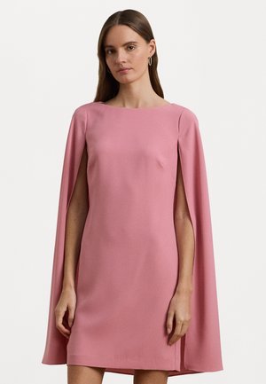 Korte roze jurk met een cape-ontwerp, zachte textuur en een vierkante halslijn; heeft een verborgen zijsplit voor extra detail.