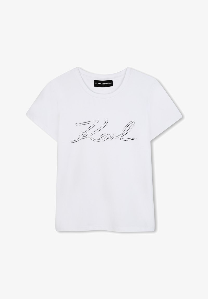 T-shirt blanc à manches courtes, arborant un design en script noir à pois "Karl" sur le devant et un col rond.