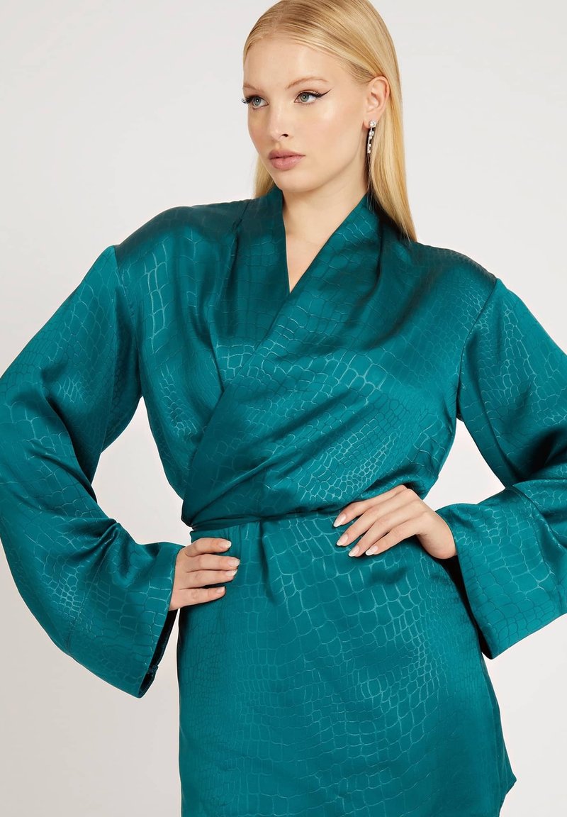 Kimono in satin turchese con un sottile motivo a coccodrillo, caratterizzato da maniche ampie e vita con cintura. Texture liscia e design elegante.