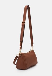 Brązowa, teksturowana skórzana torba na ramię z złotymi okuciami, regulowanym paskiem i trójkątnym kształtem. Posiada zamknięcie na zamek i widoczne przeszycia.