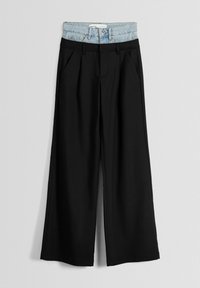 Svarta vida byxor med en strukturerad design och slät textur, med ett ljusblått denimmidja högst upp.