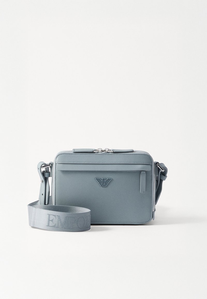 Geantă crossbody structurată, de culoare albastră, realizată din material texturat, având închidere cu fermoar, buzunar frontal și curea ajustabilă cu brandul "EMPOR".