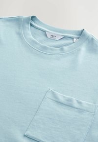 Lyseblå crew neck t-shirt lavet af en blanding af bomuld, med en frontlomme, der har en subtil tekstur og et afslappet fit design.