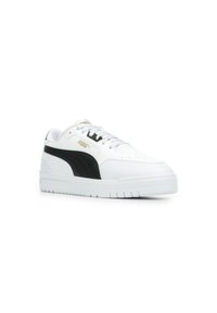 Sneaker atletiche bianche con accenti neri e marchio dorato. Presentano una tomaia in pelle liscia e una suola in gomma texturizzata con design rialzato.