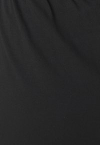 Svart tyg som visar en slät, ribbad textur; något samlad upptill. Materialet verkar lätt och elastiskt.