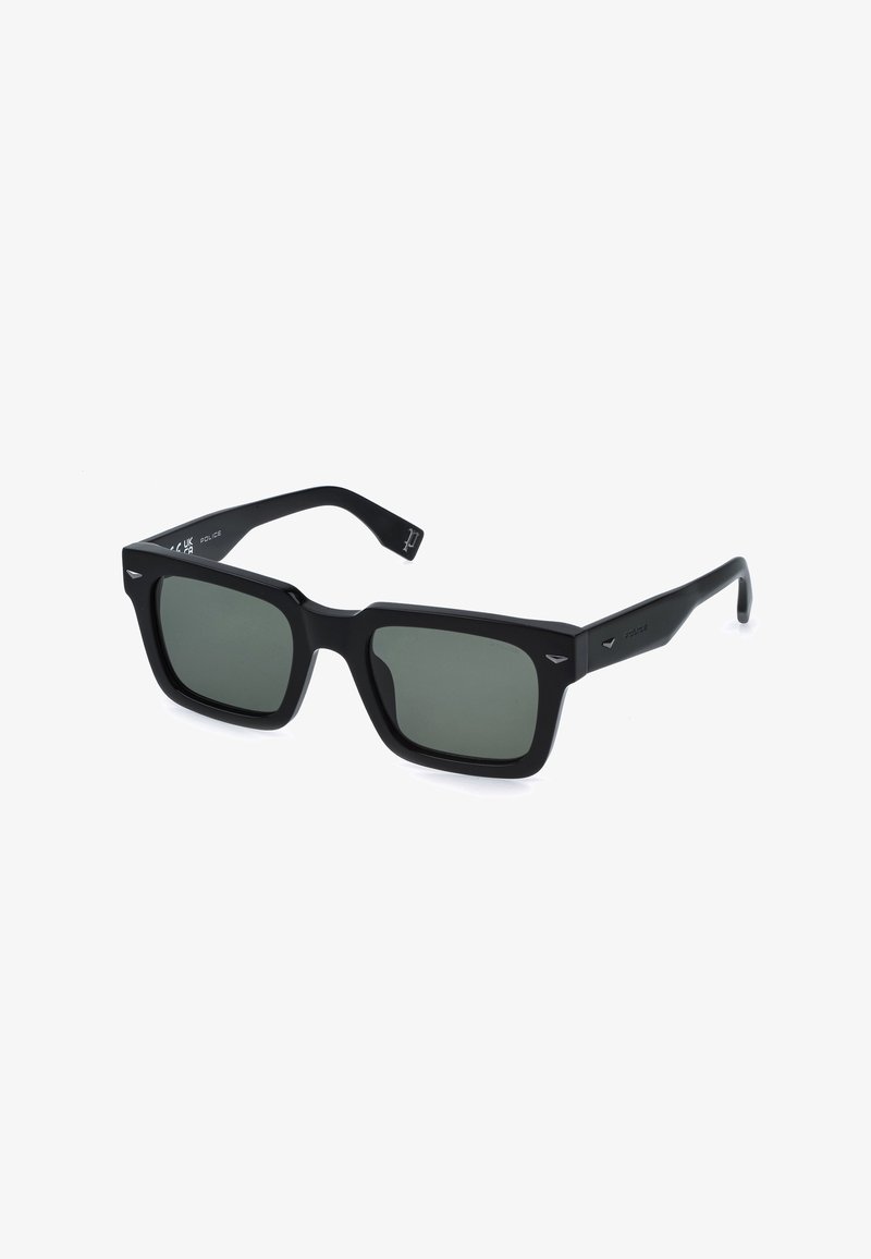 Lunettes de soleil rectangulaires noires à montures épaisses et verres vert foncé, légèrement inclinées vers la droite sur un fond blanc.