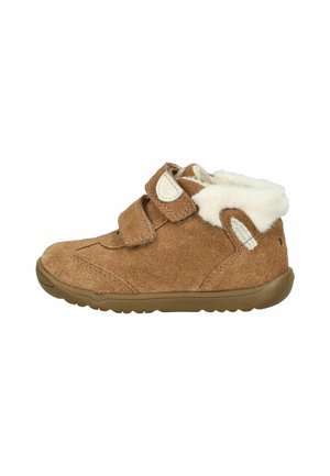 Braune Wildleder-Stiefelette mit zwei Klettverschlüssen, gefüttert mit Kunstfell und Gummisohle. Mit Steppnähten und einem kleinen Logo-Akzent.