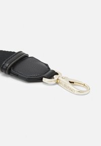 Primo piano di un bracciale in pelle nera con una chiusura metallica dorata, con il logo "Valentino" inciso sulla clip.