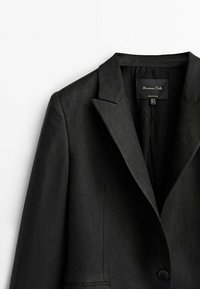 Blazer noir ajusté avec revers crantés, fermeture à un bouton et poches avant, étiquette Massimo Dutti, fabriqué au Portugal.