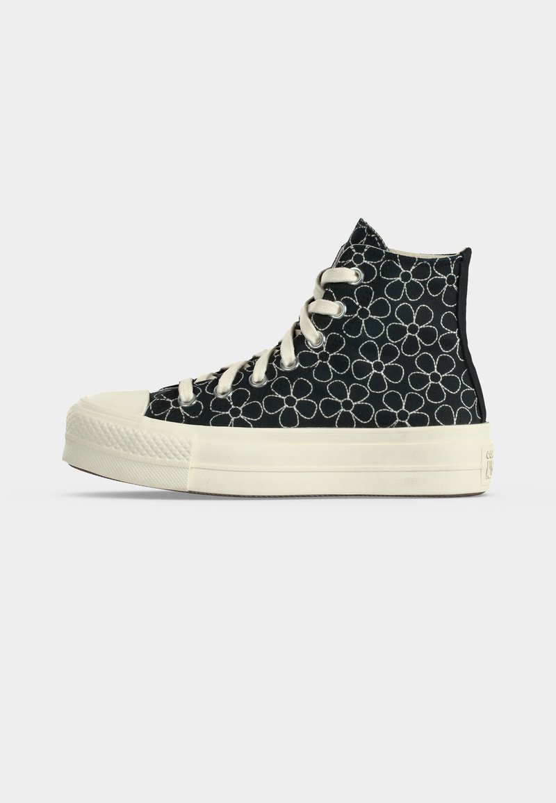 High-Top-Sneaker aus schwarzem Canvas mit weißem Blumenmuster, weißer Gummisohle und weißen Schnürsenkeln, im linken Profil vor weißem Hintergrund dargestellt.