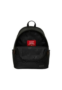 Mochila negra con un exterior texturizado, que cuenta con una etiqueta roja en el interior. El interior presenta una tela negra con un sutil patrón de plátano.