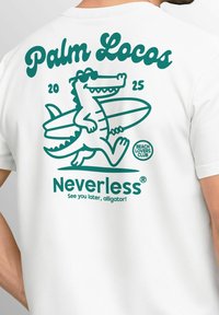 White t-shirt with turquoise graphic featuring an alligator wearing sunglasses, a surfboard, and text: "Palm Locos 2025" and "Neverless."