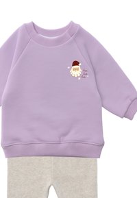 Lila Sweatshirt mit geripptem Halsausschnitt und Bündchen, mit einer Cartoon-Santa-Grafik auf der Brust. Dazu graue Leggings in Hellgrau.