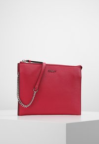 Red leather clutch with a textured finish, featuring a zipper closure and a silver chain strap. Logo embossed on the front.